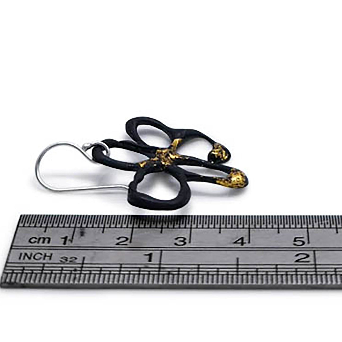 The Black Flower Gold and Sterling Silver Earrings by FR | Art Jewellery feature an abstract floral design created using the Kem-boo technique, highlighted by a striking black and gold pattern with irregular petal-like loops.