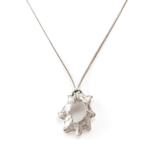 The Bondi to Bronte Collection by FR | Art Jewellery presents the exquisite Bronte Shell II Sterling silver Necklace, which features a beige cord and a gold-plated pendant. This uniquely shaped piece resembles an abstract sun or flower with its uneven edges, all set against a plain white background.