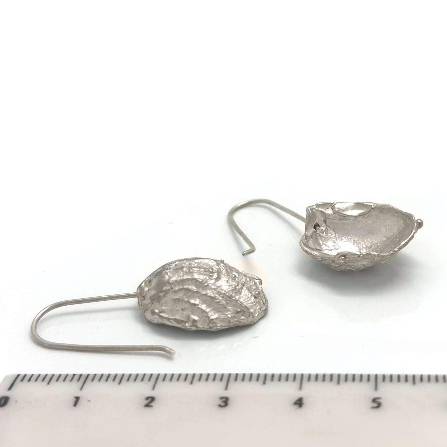 The Shelly Curve Earrings – Gold Plated in Sterling Silver by FR | Art Jewellery feature irregular, textured circular shapes and simple hook-style backings, evoking ocean-inspired designs.