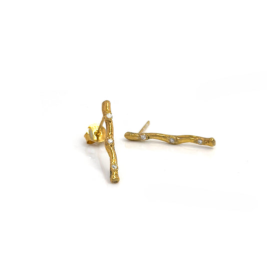 FR | Art Jewellery's Diamond Twig Earrings – Gold Plated in Sterling Silver feature a textured, nature-inspired design with clear gemstones; one earring stands upright, the other lies flat to showcase its elegant post.