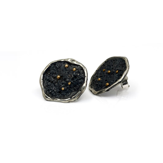 The Dream Catcher Sterling silver and gold earrings by FR | Art Jewellery feature round, textured studs with an oxidized finish, accented by gold dots and irregular silver edges—mystical Constellations Series jewelry shown on a white background.