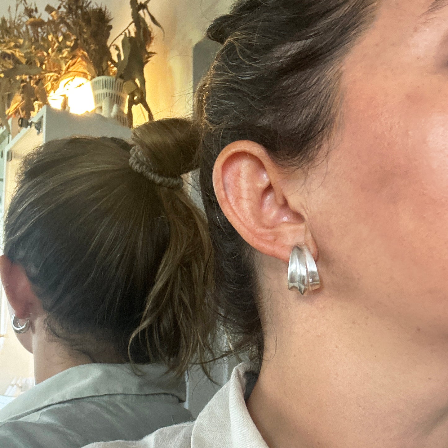 The Ebbs & Flows Earrings – Double by FR | Art Jewellery are sterling silver half-hoop earrings featuring a smooth, wavy design, shown on a white background—ideal for those who love nature-inspired jewellery.