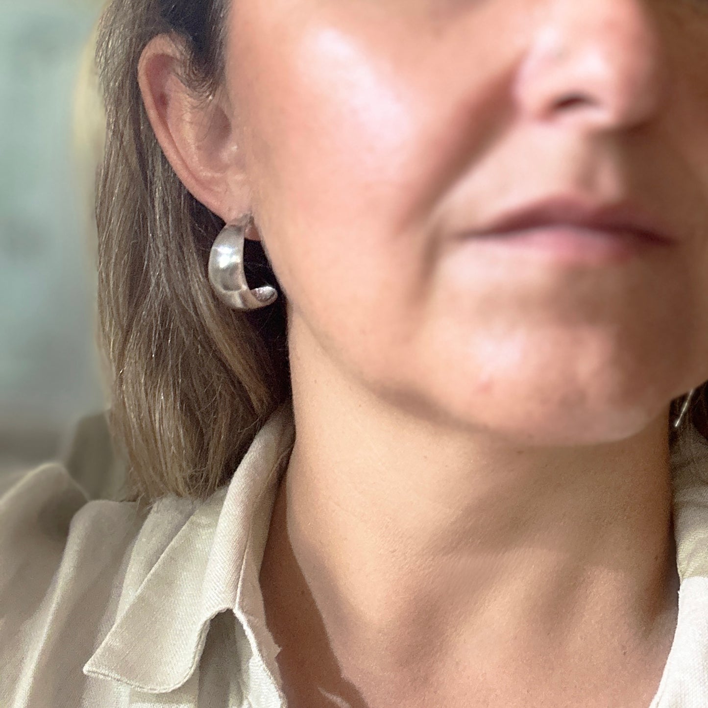 The Ebbs & Flows Earrings – Curve Sterling Silver by FR | Art Jewellery are displayed upright on a white background, highlighting their smooth, shiny surfaces and elegant rounded form.