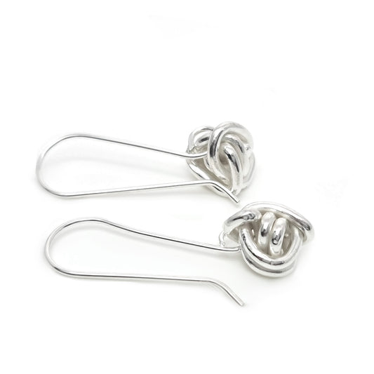 From FR | Art Jewellery's Endlessly collection, these sterling silver earrings feature a twisted knot design on a white background. Each piece showcases the intricate artistry typical of our handmade jewellery.