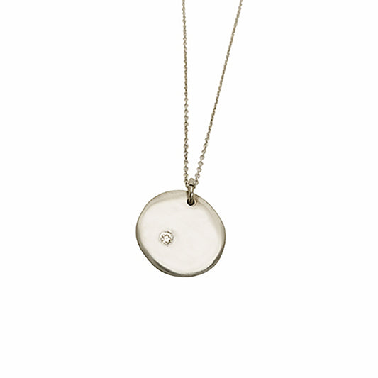 Introducing the Full Moon Sterling Silver and Gold Necklace, an exquisite piece of handmade jewelry by FR | Art Jewellery. This necklace features a round pendant with a single diamond elegantly set into its surface, gracefully hanging from a delicate gold chain against a pristine white background.