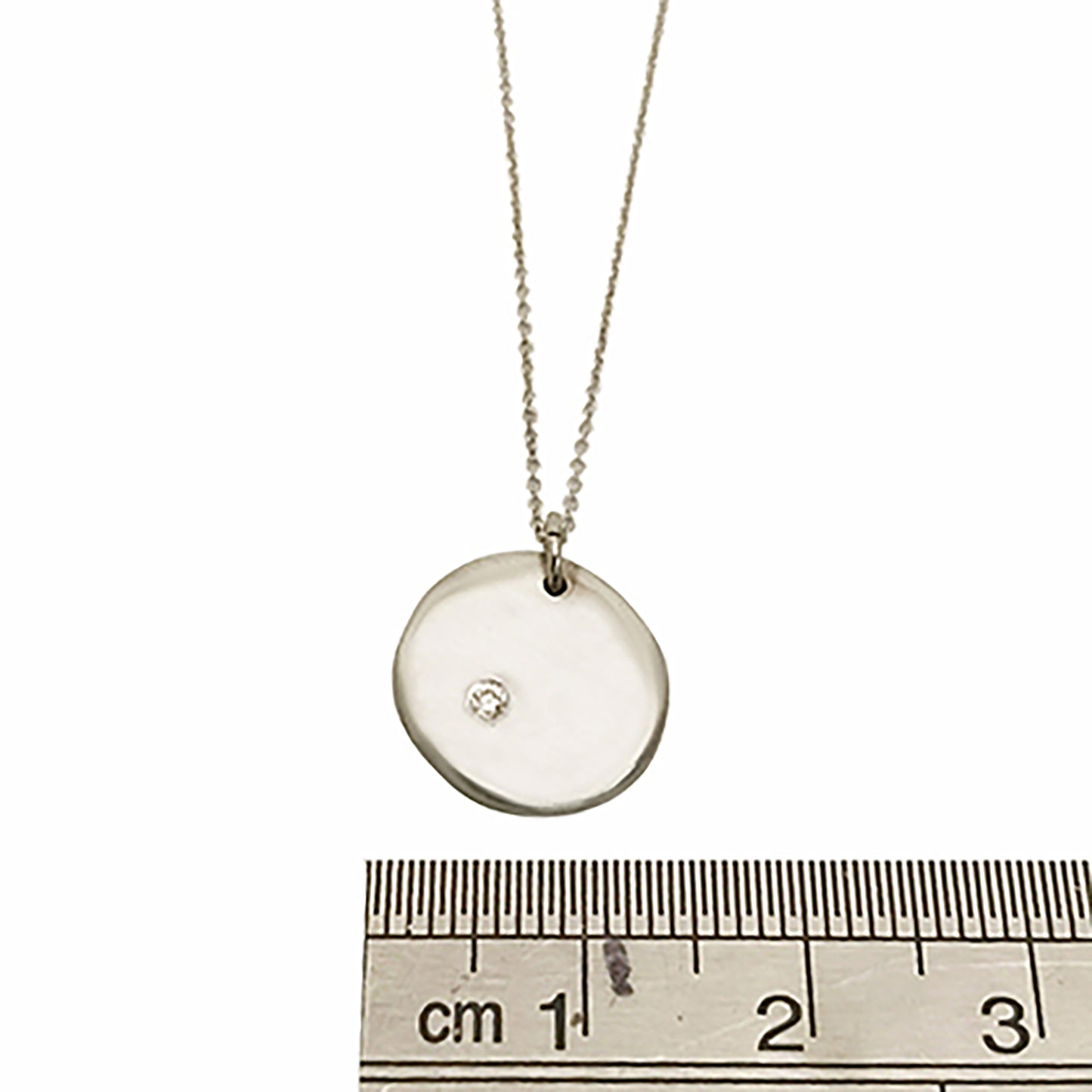 Introducing the Full Moon Sterling Silver and Gold Necklace, an exquisite piece of handmade jewelry by FR | Art Jewellery. This necklace features a round pendant with a single diamond elegantly set into its surface, gracefully hanging from a delicate gold chain against a pristine white background.