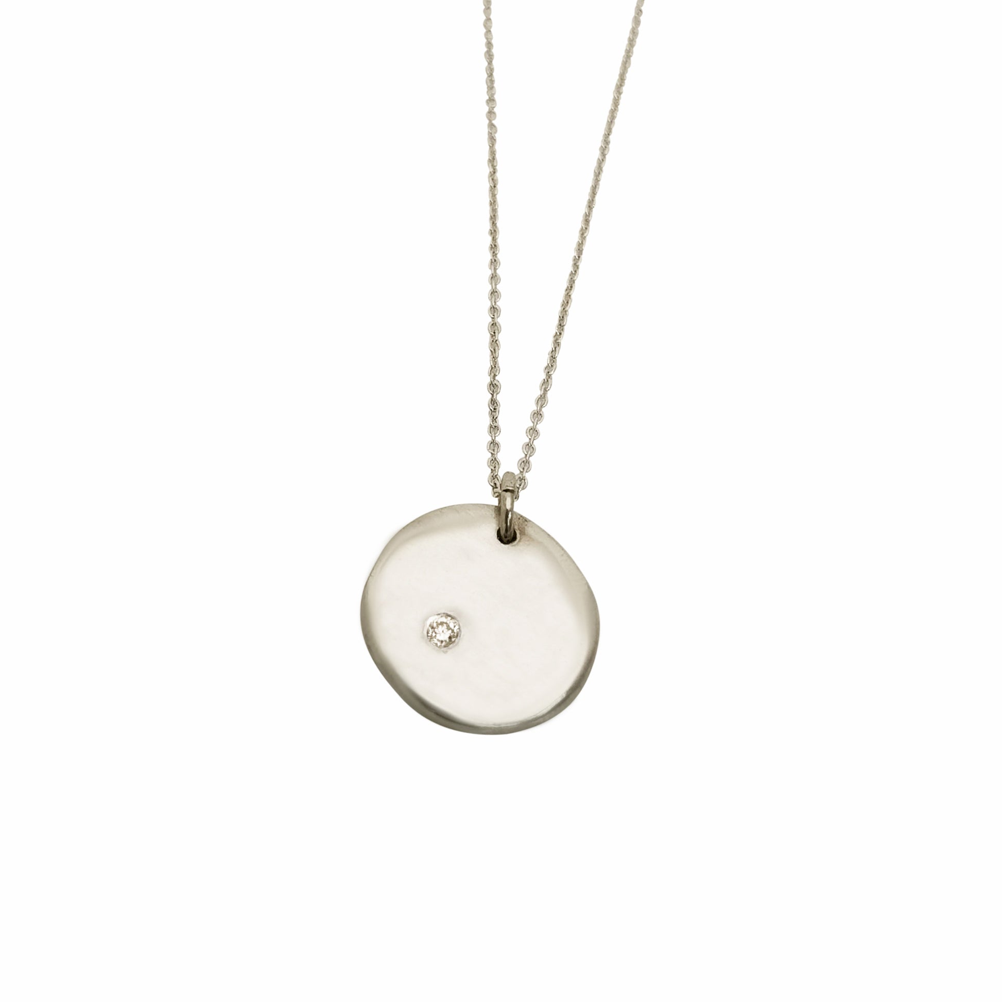 Introducing the Full Moon Sterling Silver and Gold Necklace, an exquisite piece of handmade jewelry by FR | Art Jewellery. This necklace features a round pendant with a single diamond elegantly set into its surface, gracefully hanging from a delicate gold chain against a pristine white background.