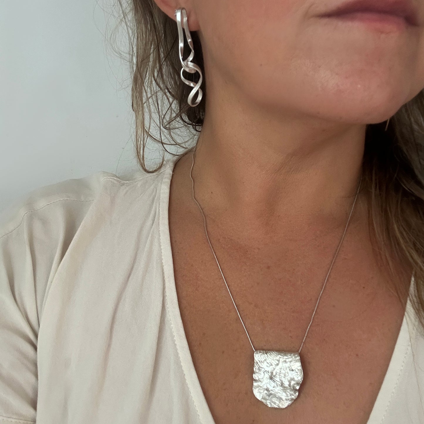 Handmade sterling silver organic pendant necklace with sculptural textured surface by FR Art Jewellery model