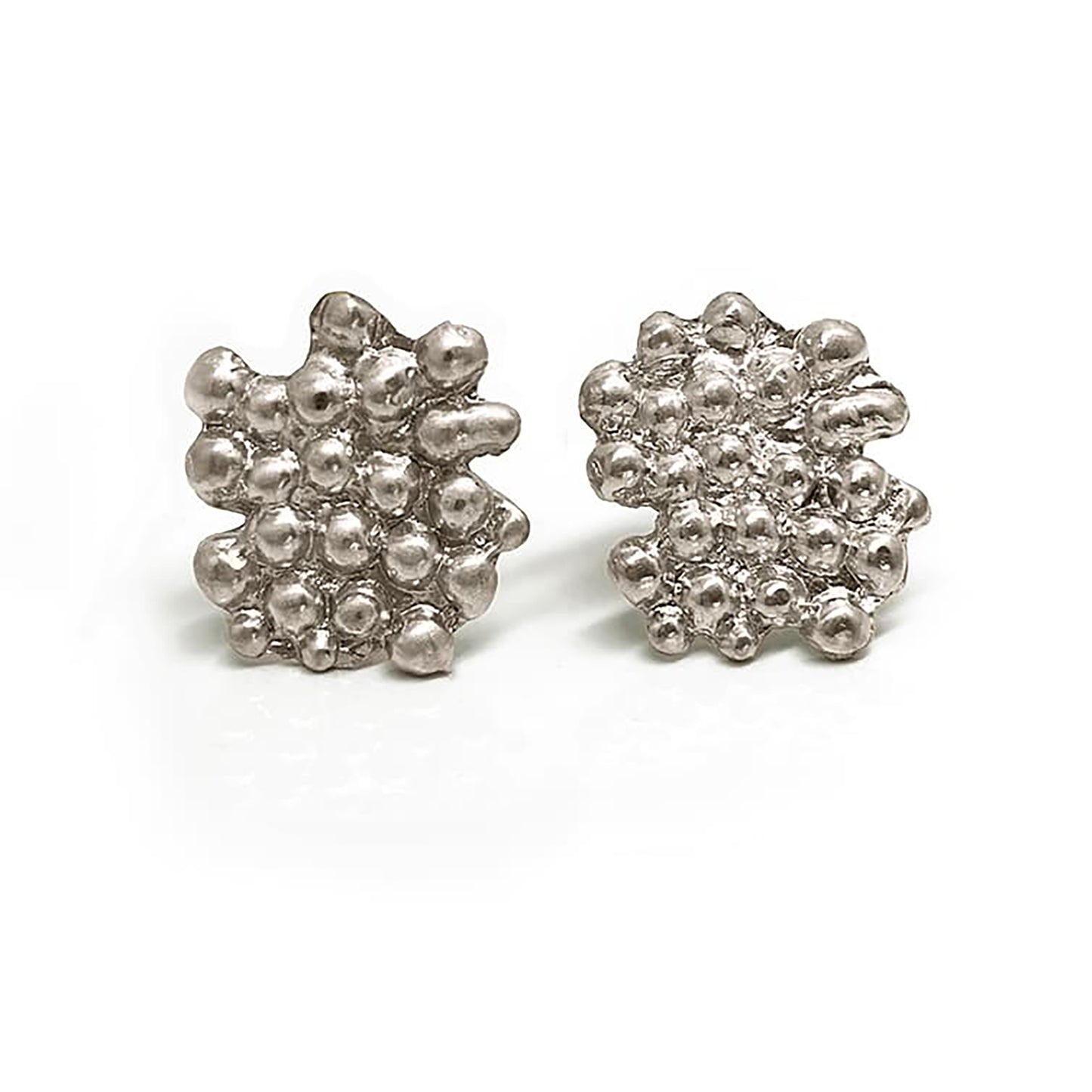 A pair of Perlas Earrings in Sterling Silver by FR | Art Jewellery features a textured, irregular cluster design of small rounded bumps—one earring faces forward, the other shows the side and post, perfect for lovers of unique style.