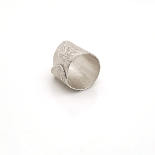 The Silver Leaf Ring by FR | Art Jewellery features a wide, textured sterling silver band with an organic, asymmetrical edge. This handmade, nature-inspired adjustable design is pictured on a plain white background.