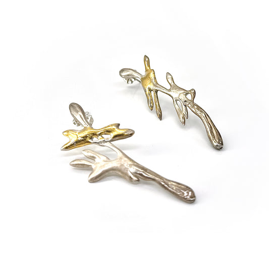 The Symbiosis Sterling Silver Earrings by FR | Art Jewellery feature two abstract, bird-inspired designs—one with 24ct gold Keum-boo, the other in silver—creating bold handmade statement pieces shown on a white background.
