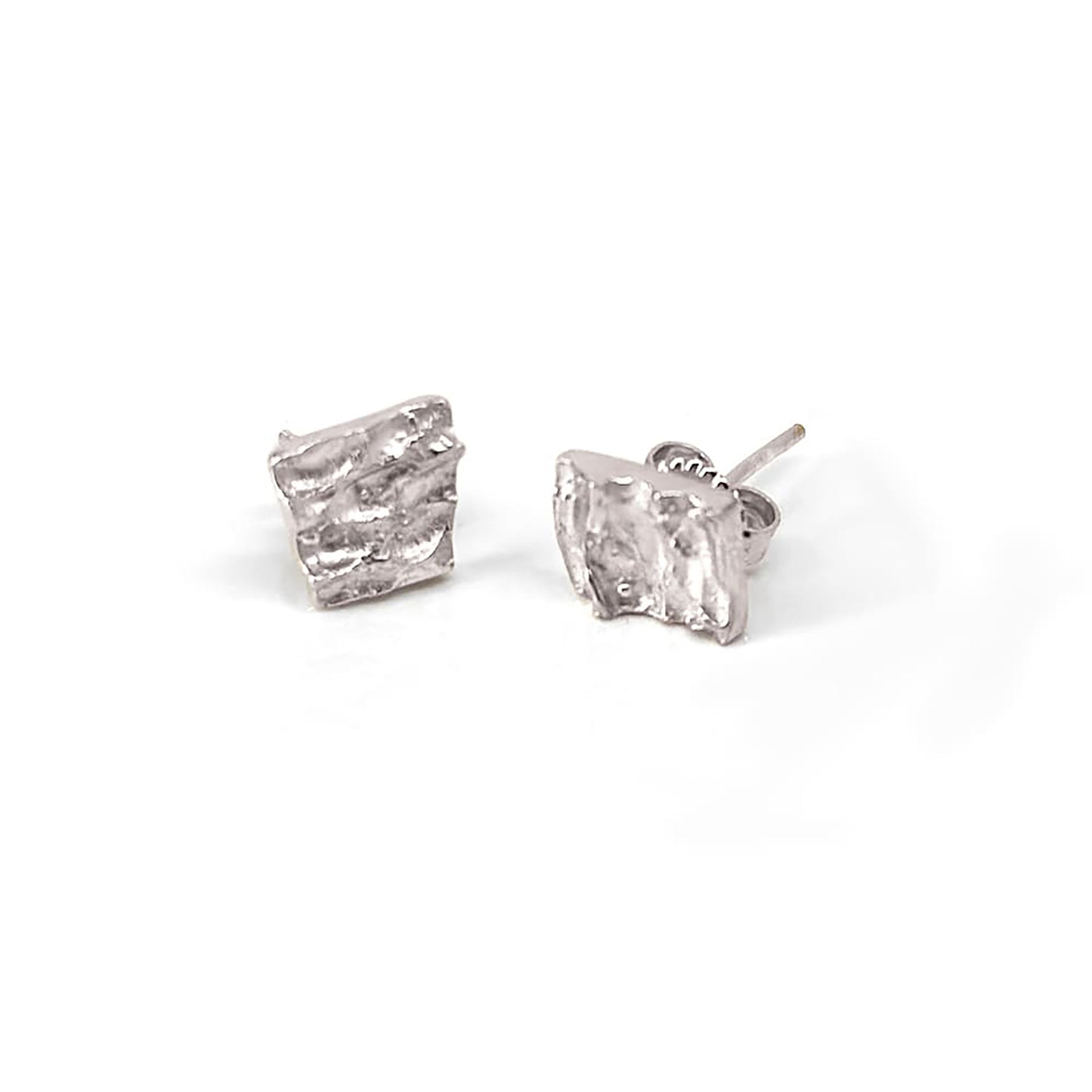 The Tribu Earrings in Sterling Silver by FR | Art Jewellery are small, square-shaped hammered studs with a textured, wavy surface, perfect for everyday wear and shown against a white background.