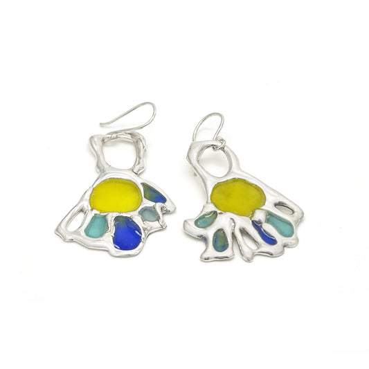 From FR | Art Jewellery's Colour Collection, the Vitro Hand Sterling Silver Earrings are handmade resin studs featuring abstract fan-shaped designs in blue, green, teal, and orange. Lightweight and vibrant for any look.