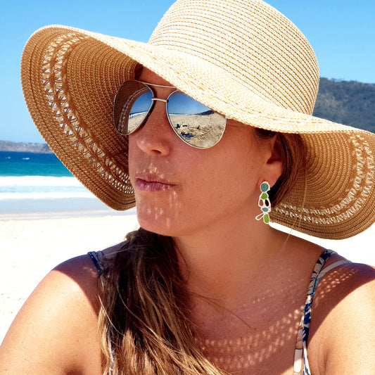 The Vitro Blue and Green Earrings by FR | Art Jewellery showcase an abstract design with green and turquoise enamel accents. These sterling silver earrings feature an organic, flowing shape, creating an artistic and modern look against a white background, making them perfect for your Colour Collection.