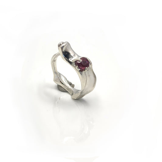 Handmade sterling silver sculptural Water Ring with pink-red spinel gemstone, wave-inspired organic design.