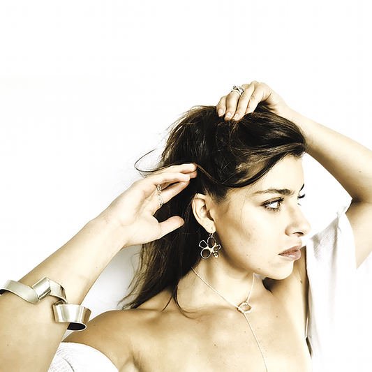 The Black Flower Gold and Sterling Silver Earrings by FR | Art Jewellery feature an abstract floral design created using the Kem-boo technique, highlighted by a striking black and gold pattern with irregular petal-like loops.