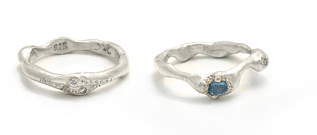 Handcrafted silver ring with blue gemstone on marble surface, photographed in natural light — showcasing sculptural elegance and contemporary design by FR | Art Jewellery.