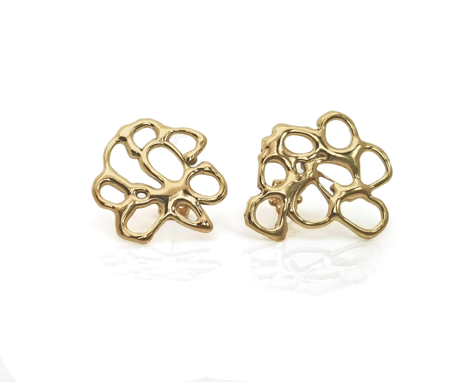 A pair of gold intricate openwork earrings with an abstract, organic design, featuring irregularly shaped loops and cutouts. The earrings are slightly reflective and laid on a white background.