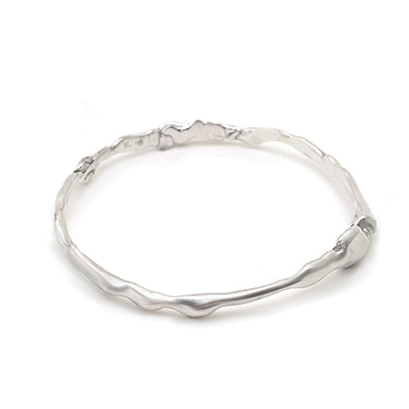 A minimalist, irregularly shaped silver bangle bracelet with a wavy, organic design. The smooth, shiny surface gives it a modern and elegant appearance.