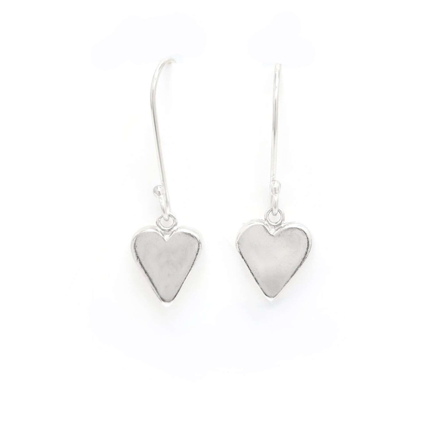 A pair of silver heart-shaped dangle earrings with hooks, set against a white background.