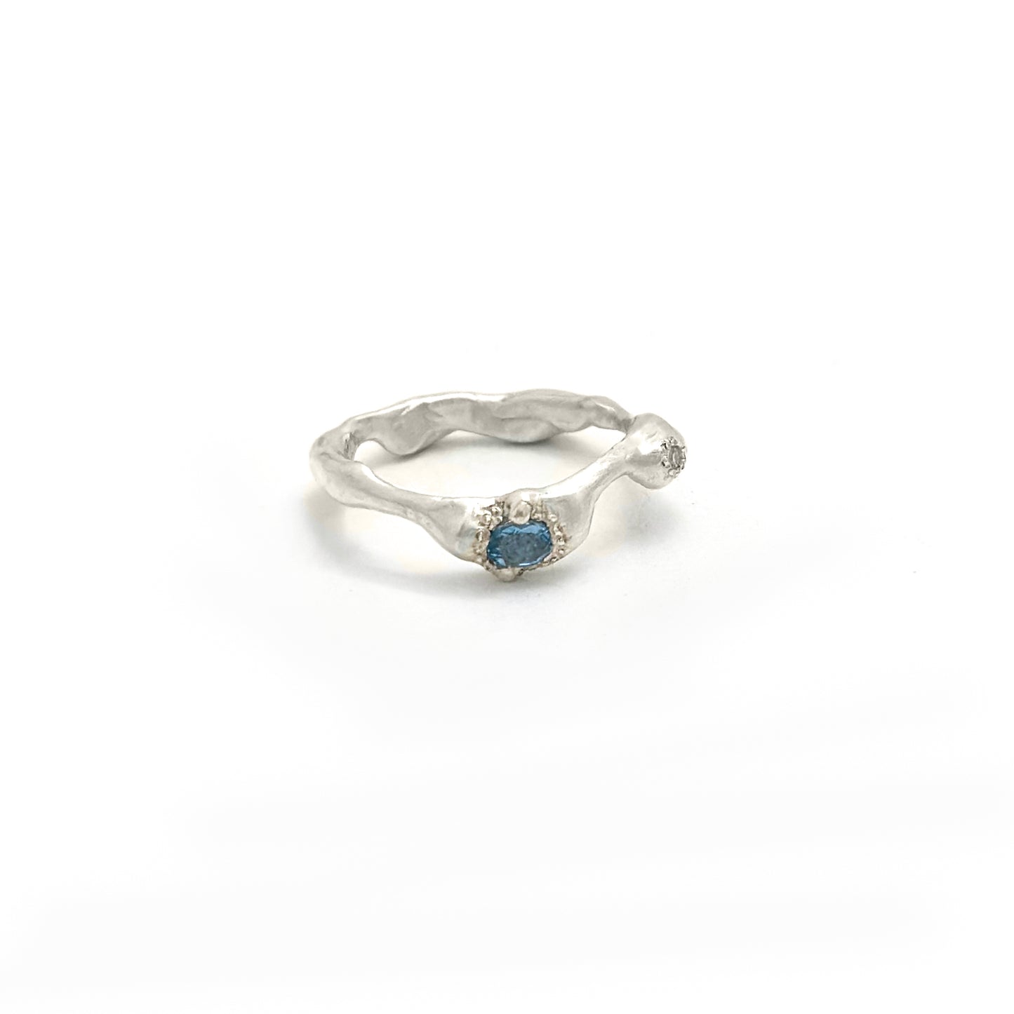 The Aquamarine and Diamond Ring by FR | Art Jewellery is a handmade sterling silver ring from Sydney, featuring a wavy organic band and a central blue gemstone, shown against a plain white background.