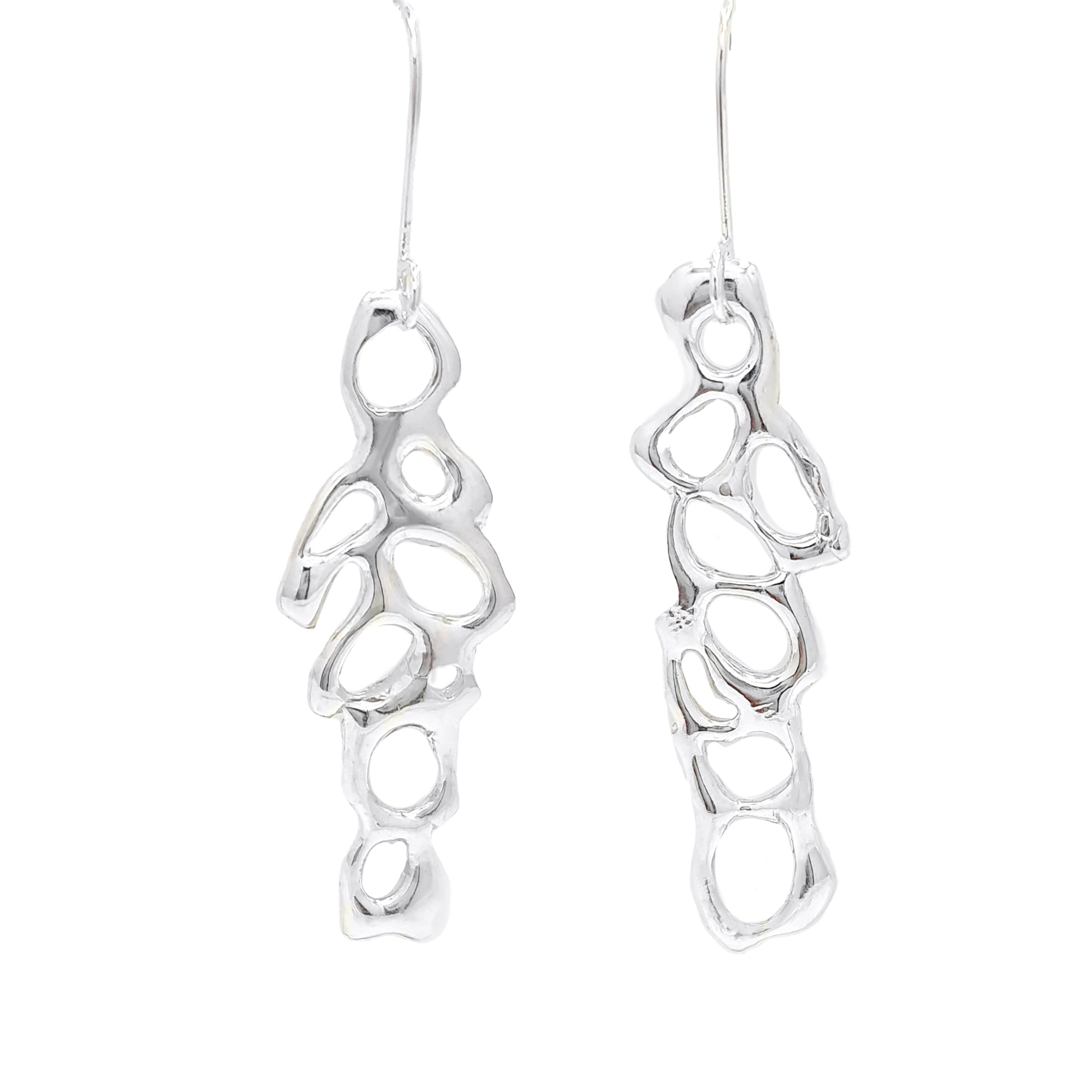 Introducing the "Angel Earrings" by FR | Art Jewellery: a stunning pair of silver earrings featuring an abstract, organic design with irregularly shaped open cutouts. This handmade jewellery piece boasts long hooks for easy insertion into pierced ears and a shiny, polished finish.