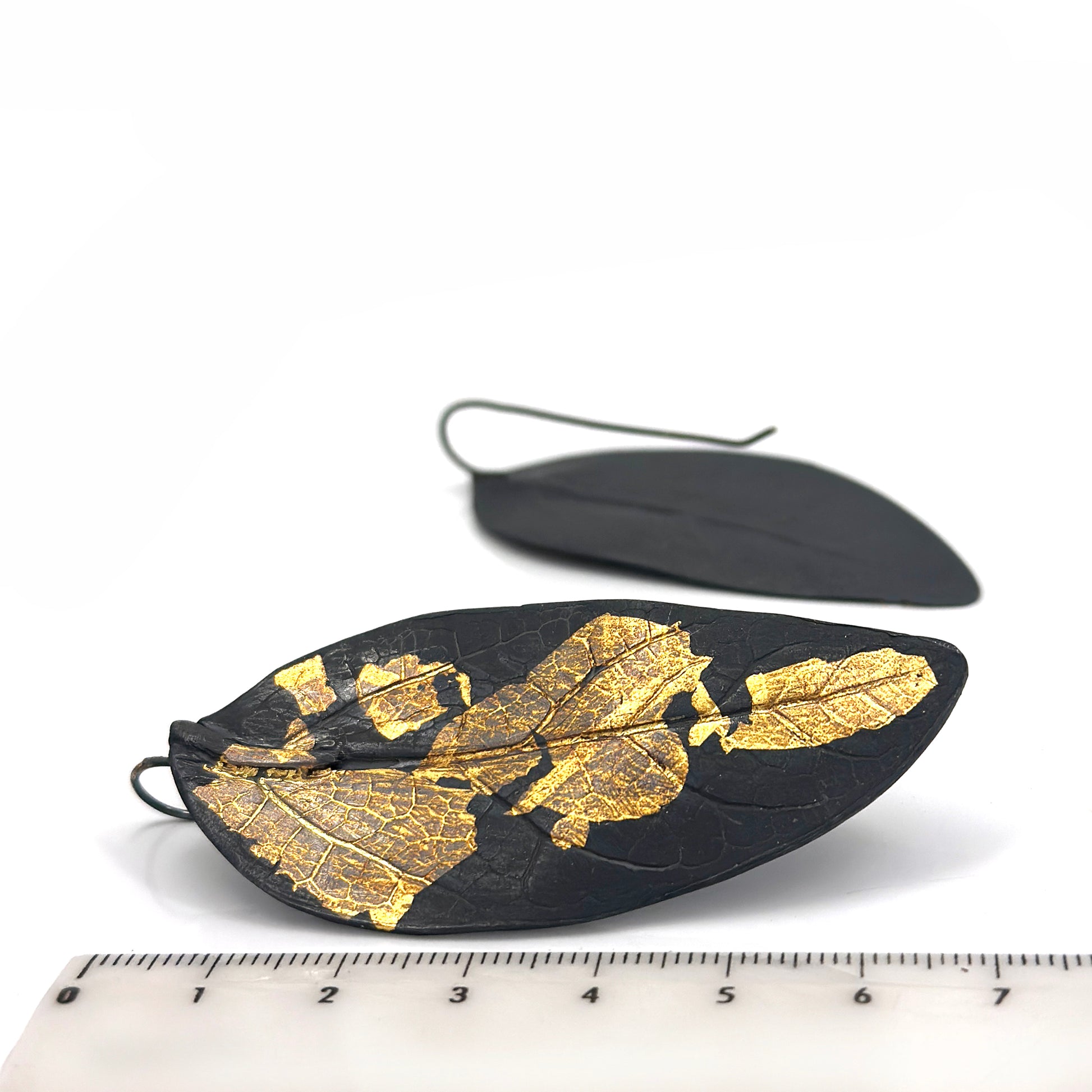 Close-up of the Black Leaf Sterling Silver Earrings by FR | Art Jewellery, showcasing the intricate veins and textures against a plain white background.