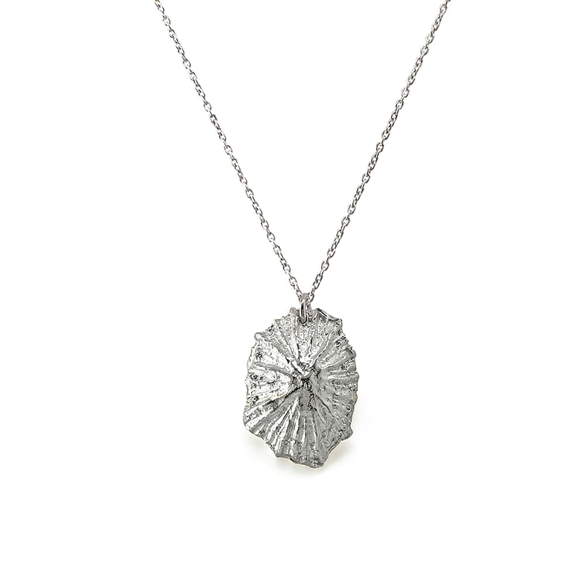 Introducing the Bondi Shell II Necklace from FR | Art Jewellery, a gold necklace with a delicate chain featuring a textured, irregularly shaped pendant. This handmade piece boasts a rough, organic design with a radial pattern reminiscent of natural elements, adding unique and rustic charm to your collection.