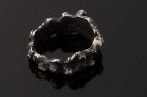 The Bottom Of The Sea Ring by FR | Art Jewellery is a sterling silver ring with an uneven, textured, organic surface, inspired by contemporary art jewellery. Displayed on a white background.