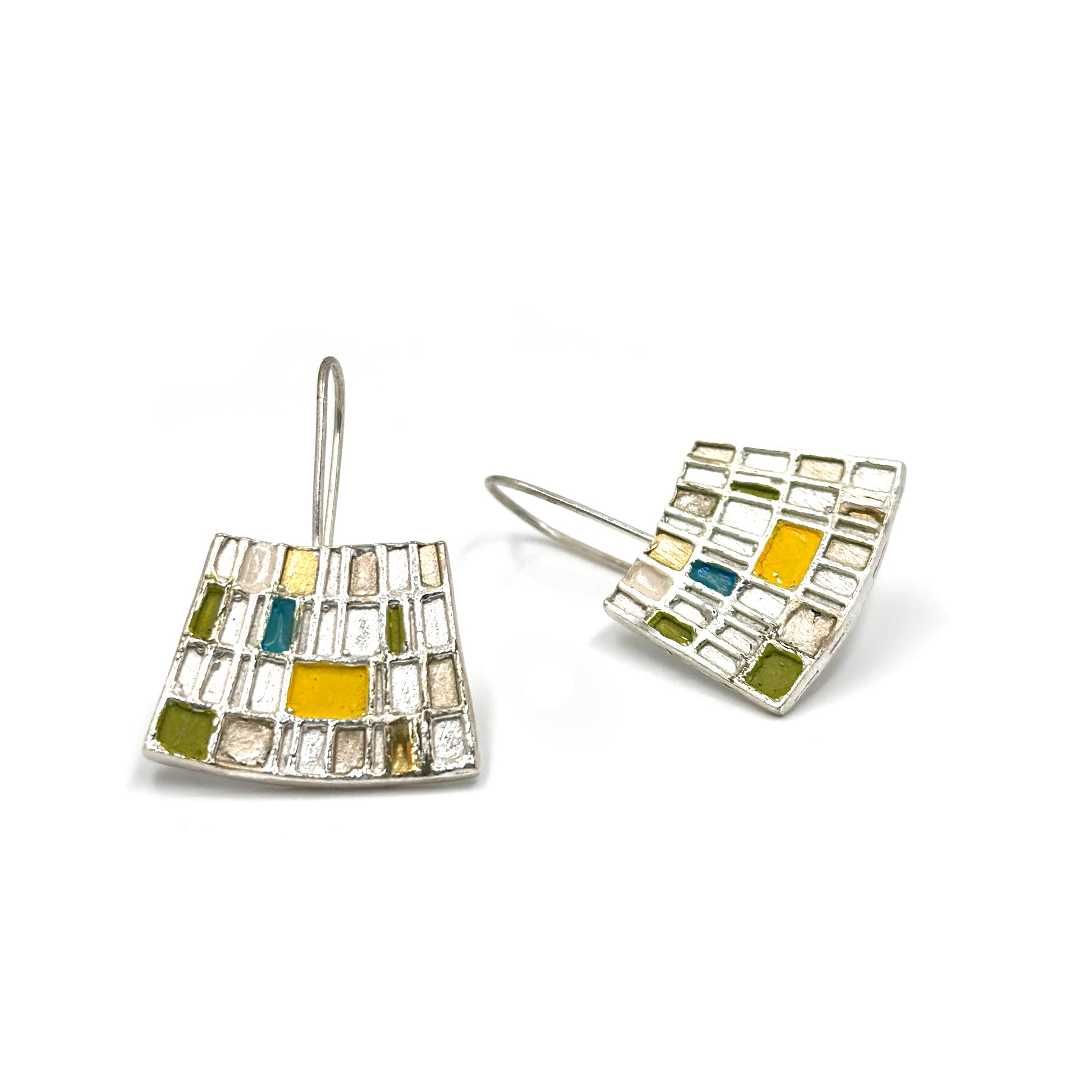 Introducing the Curve Klimty Earrings by FR | Art Jewellery, a stunning pair of gold-plated silver earrings featuring a square mosaic design. The squares are beautifully filled with an array of colors, including yellow, green, and blue. These handmade pieces showcase a modern, geometric style and hang elegantly from simple hooks. Custom-made orders are available upon request.