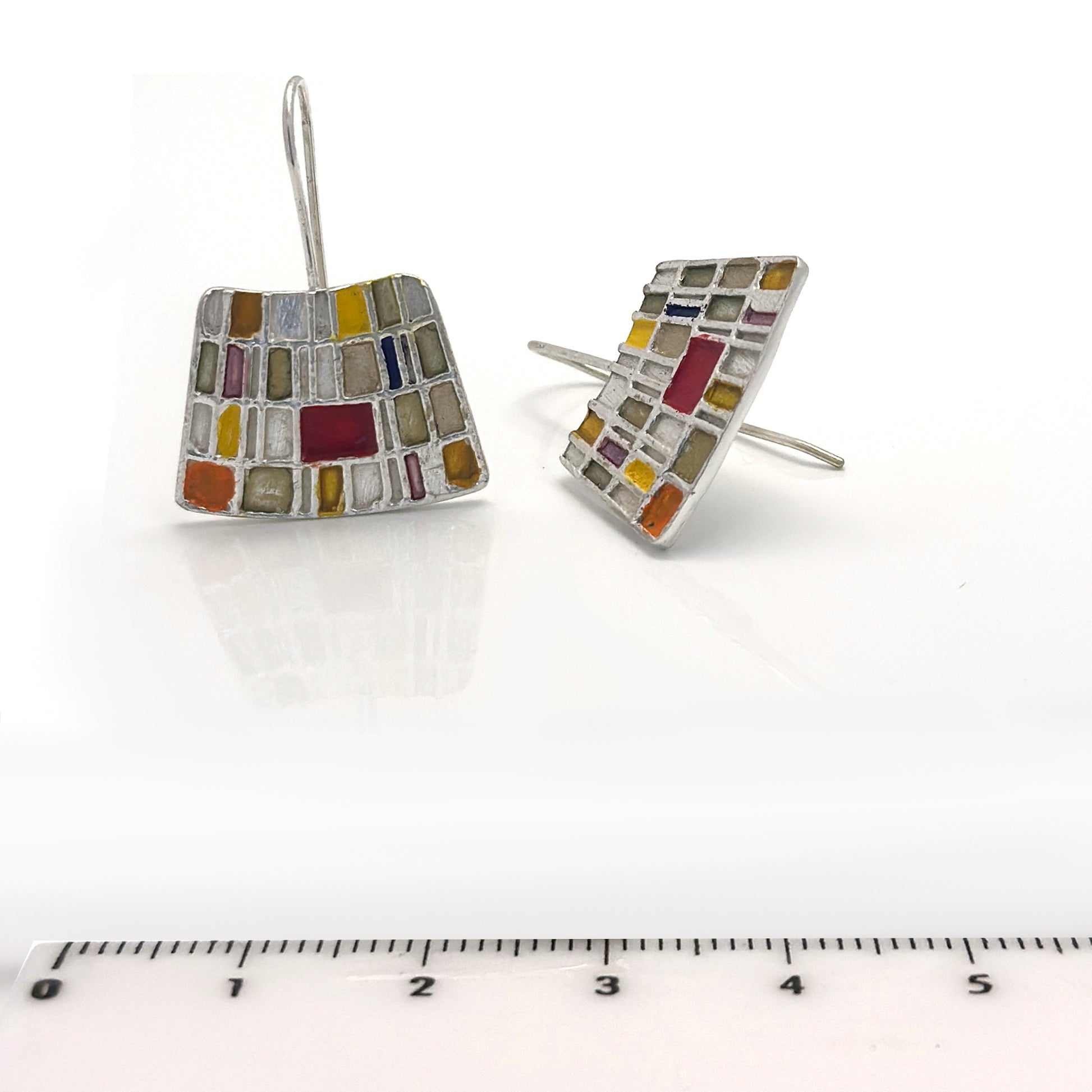 curve klimt read orange yellow enamel to a sterling silver earring with a ruler to measure size