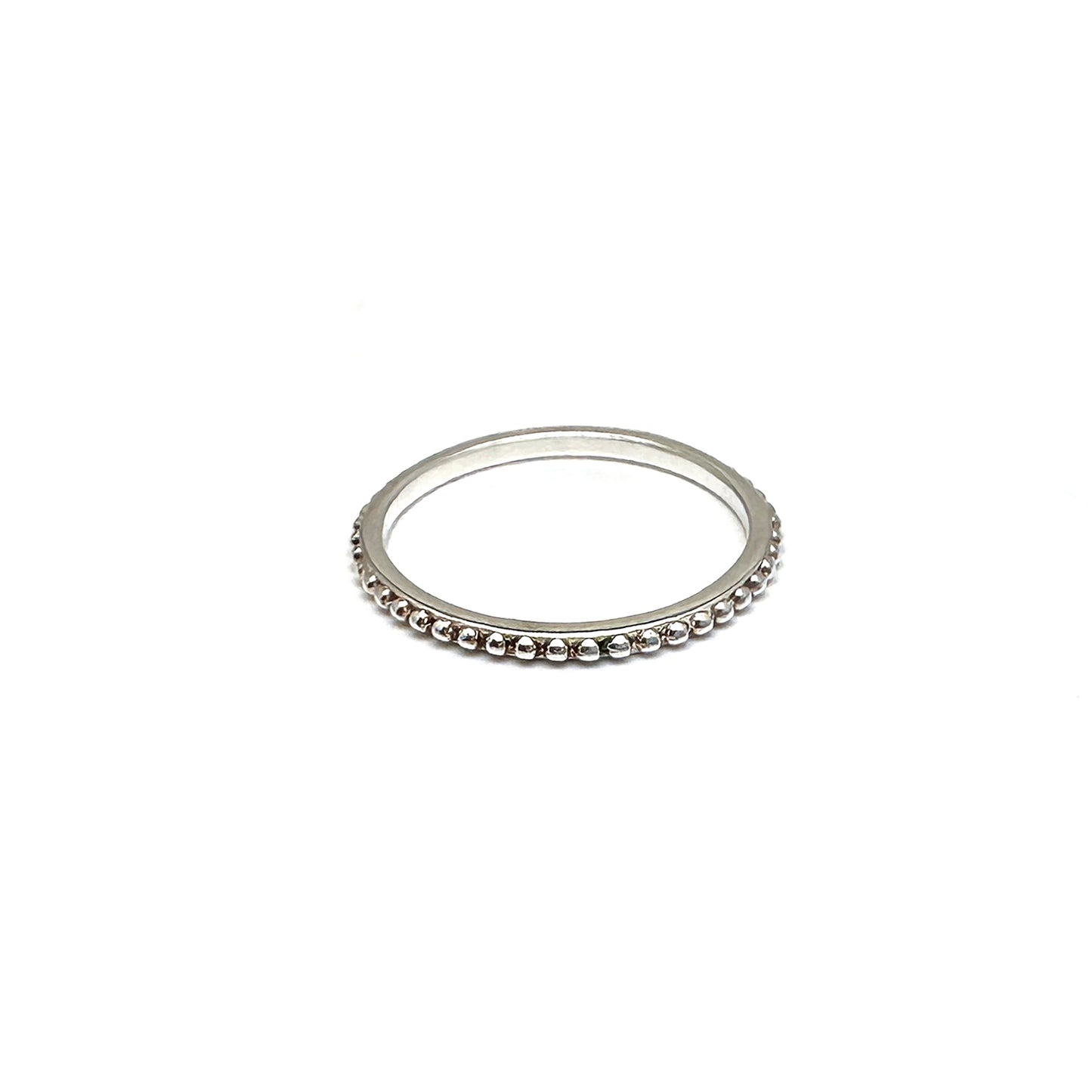 The FR | Art Jewellery Stackable Dot Ring features a single row of small, round silver beads uniformly arranged. The ring is elegantly displayed against a plain white background.