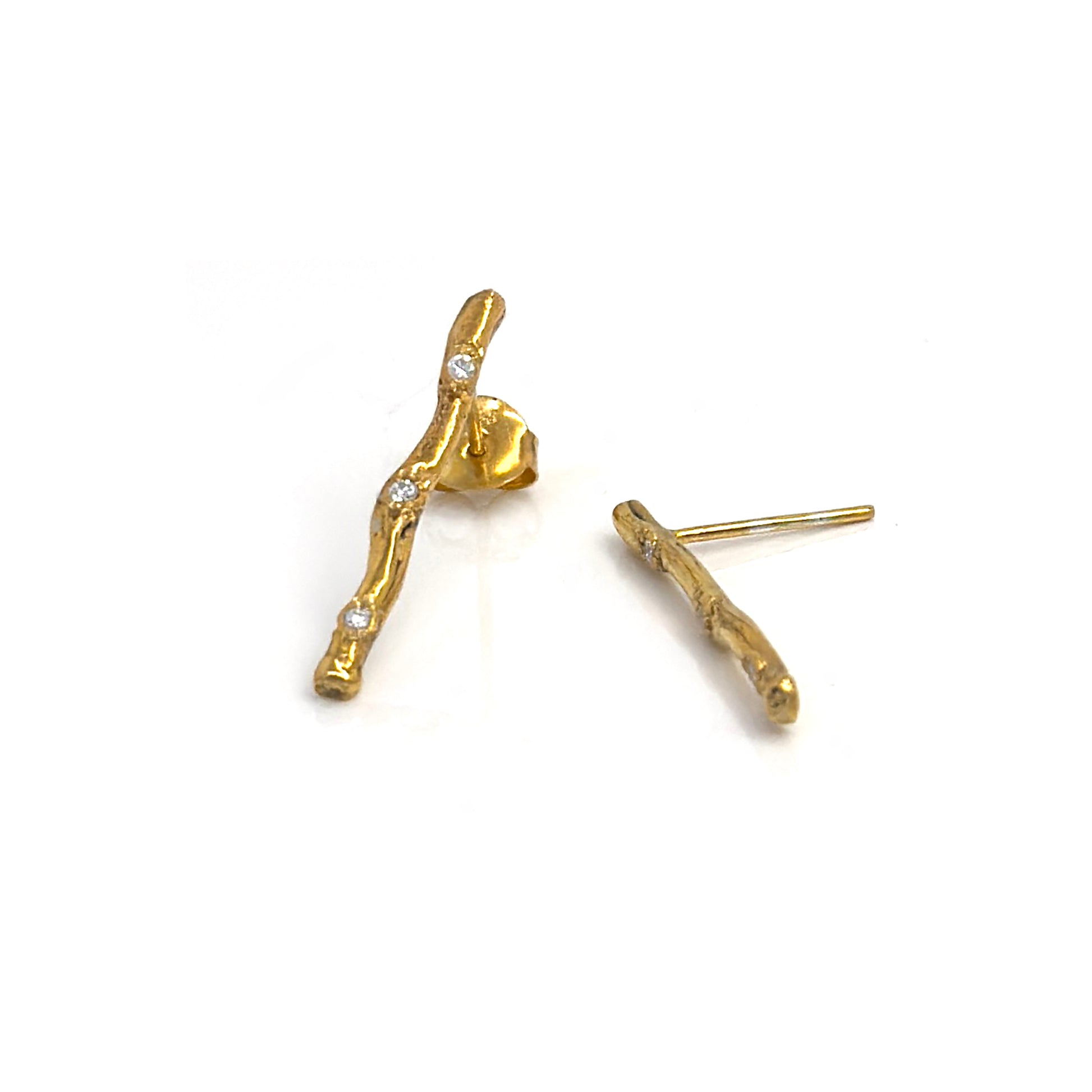 FR | Art Jewellery's Diamond Twig Earrings – Gold Plated in Sterling Silver feature a textured, nature-inspired design with clear gemstones; one earring stands upright, the other lies flat to showcase its elegant post.