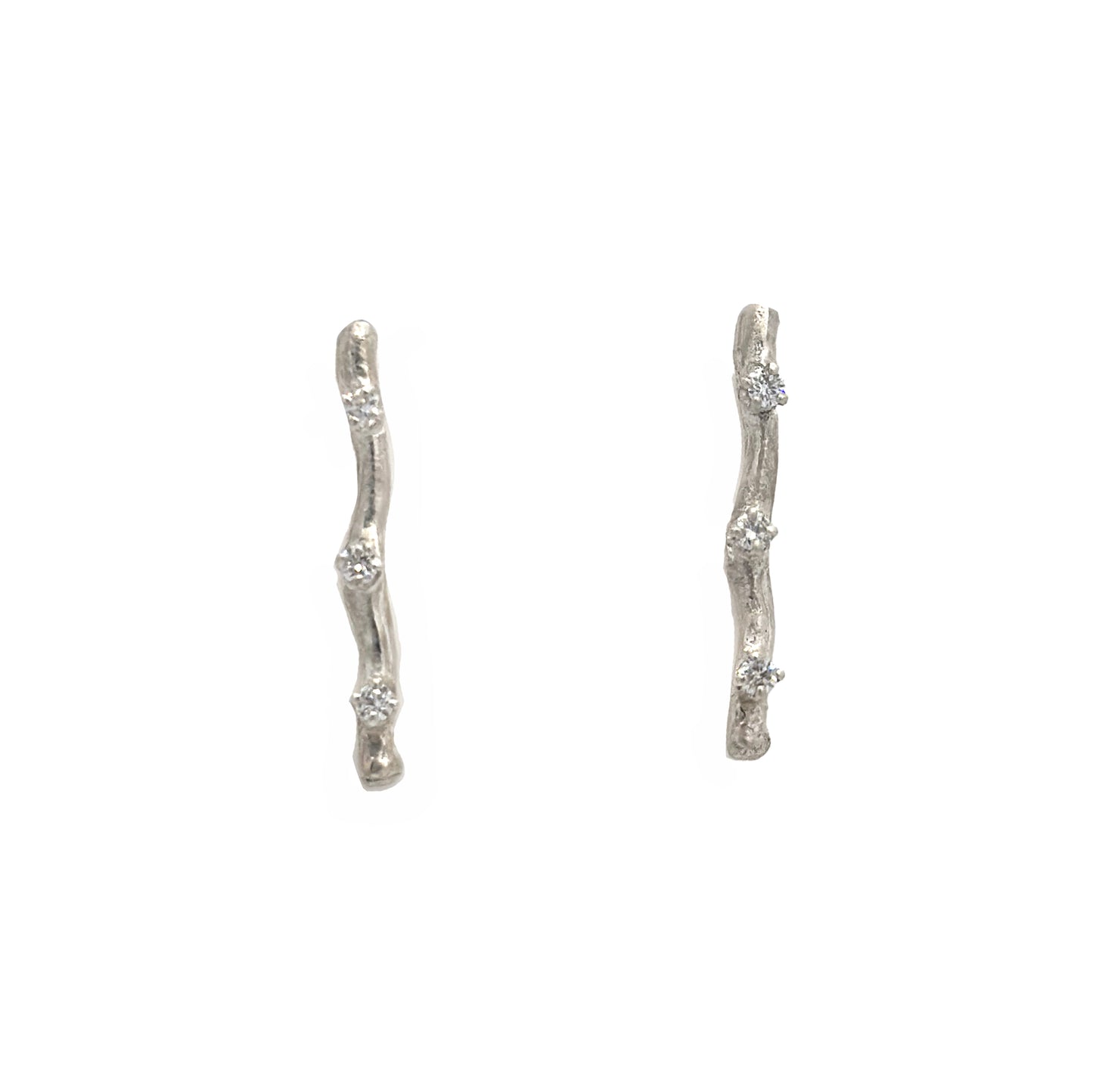 Pair of twig silver earrings with small diamond on a white background