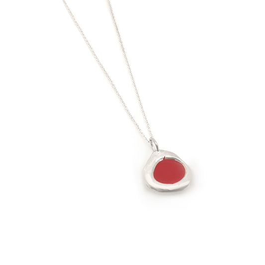 The Drop of Colours Necklace from our FR | Art Jewellery Colour Collection showcases a delicate silver chain paired with a small, irregularly-shaped pendant featuring a vibrant red circular center. The minimalist design is enhanced by the simple, thin chain, and the pendant's glossy finish adds to its polished appearance.