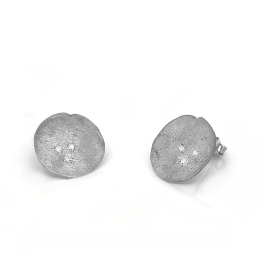 FR | Art Jewellery's Ebb & Flow Round Earrings Large are handcrafted sterling silver studs with a matte finish and three diamond accents at the center, presented against a white background.