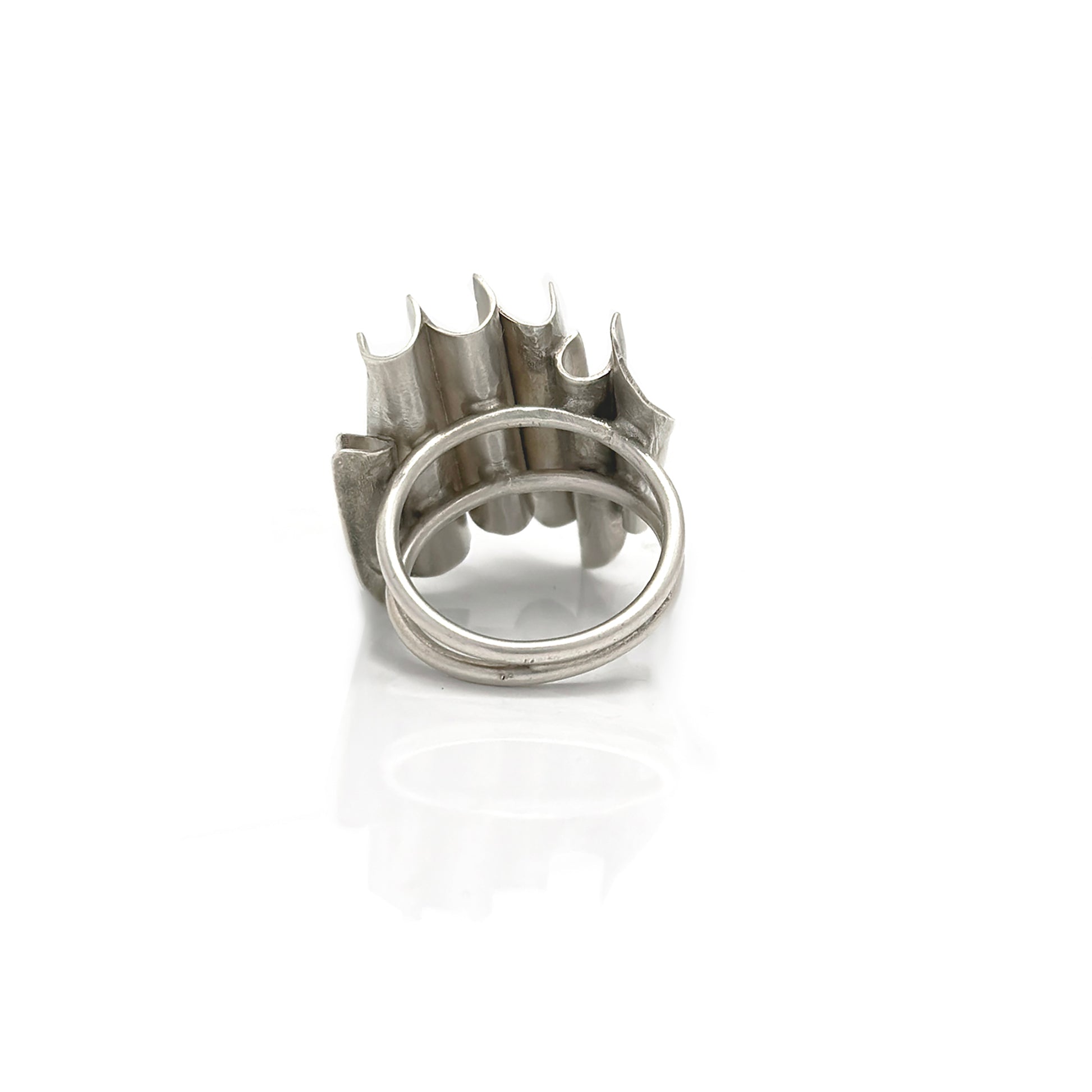 Pictured is the Encrusted Ring by FR | Art Jewellery, a striking piece of handmade jewelry featuring a unique wavy and layered design. This wide, silver ring boasts an elongated, oval-shaped green gemstone set asymmetrically within one of the wavy layers, creating an abstract and modern aesthetic. The ring stands out beautifully against the white background.