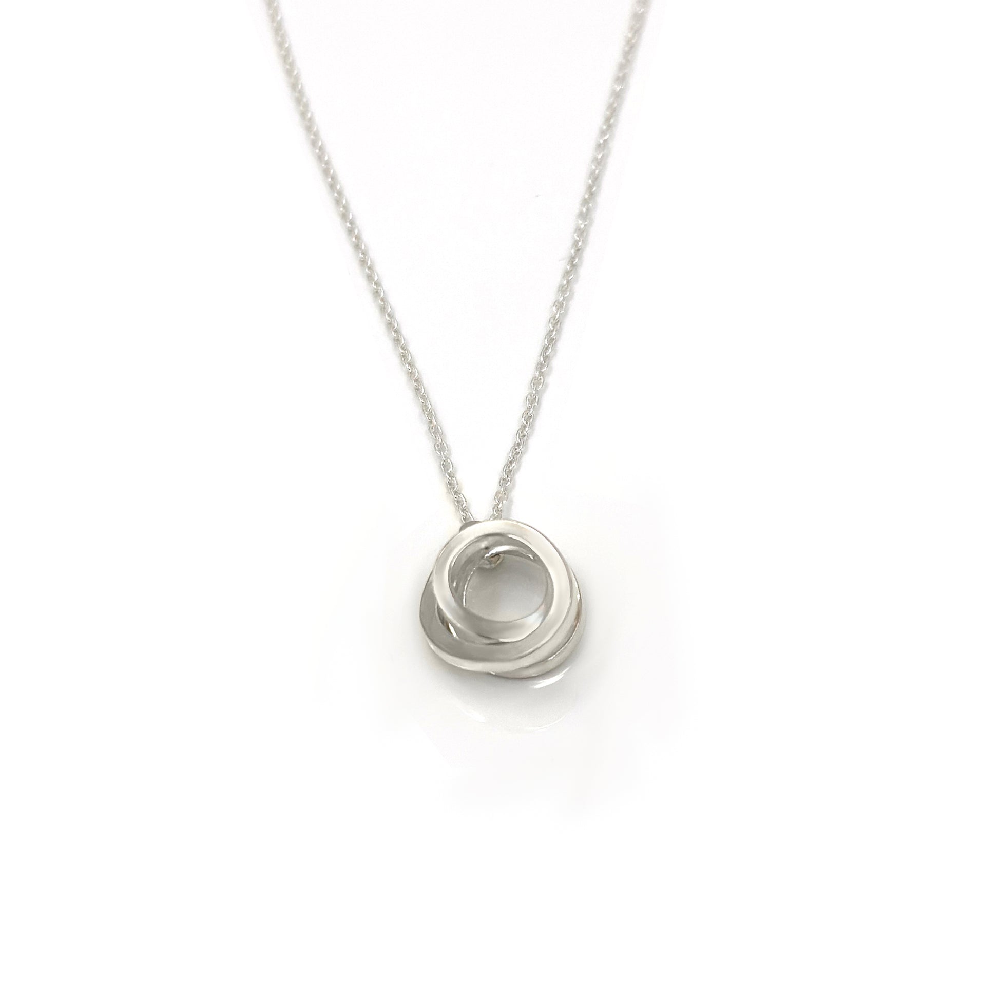 Introducing the Endless Necklace by FR | Art Jewellery: a stunning silver necklace showcasing a delicate chain and a pendant of intricately interlocking circles. The circles are smoothly polished, embodying an elegant and timeless design. The simplicity of the chain accentuates the intricate pattern of the pendant, perfectly representing our commitment to exquisite handmade jewellery.