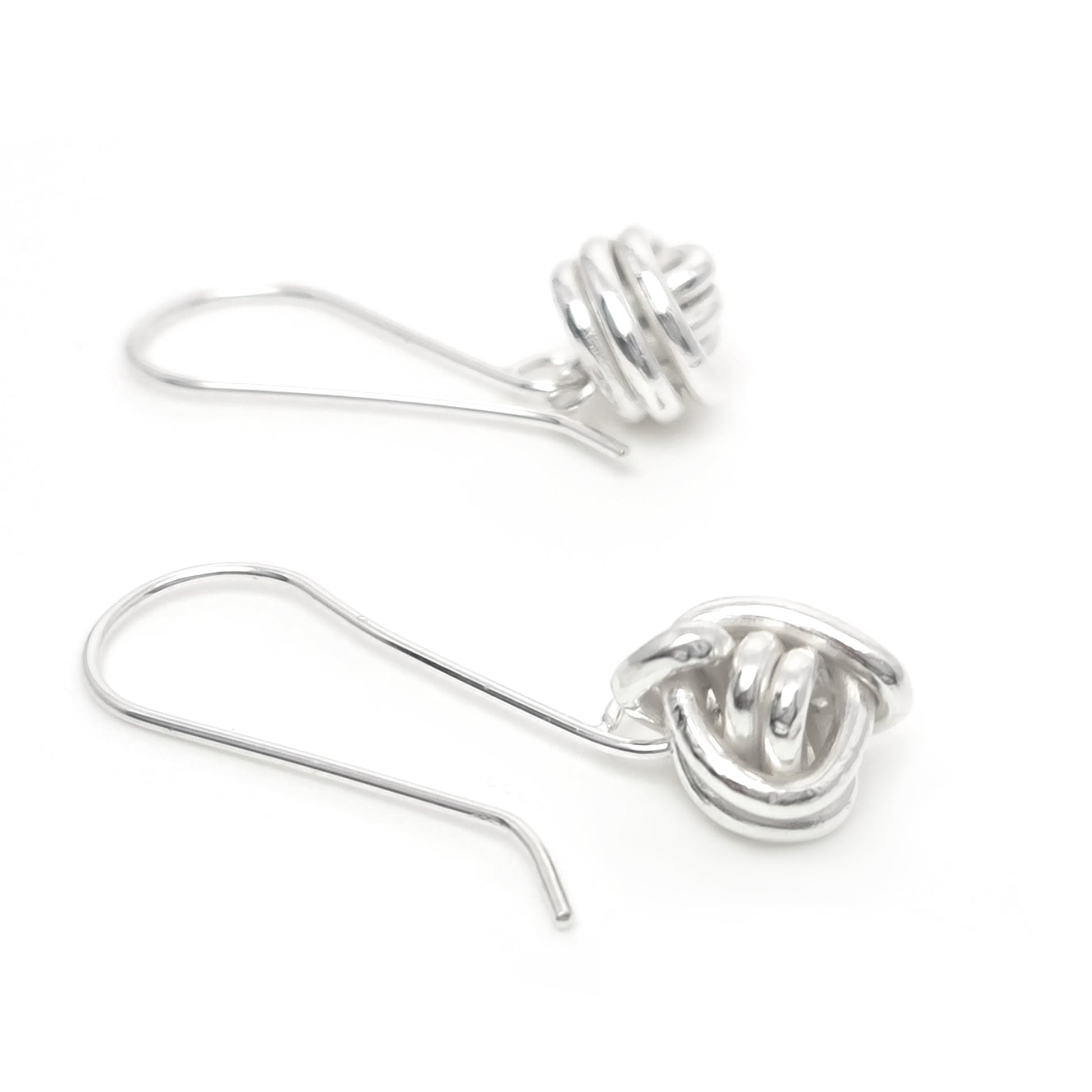 A pair of Endlessly Earrings by FR | Art Jewellery is displayed against a white background. Each handmade silver earring features a hook design with an intricately twisted, knot-like detail at the end. These modern and elegant earrings are perfect for custom-made orders.