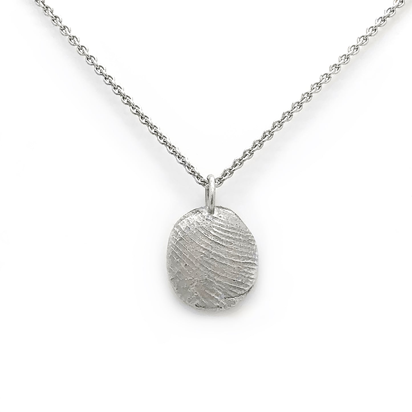 A gold fingerprint necklace with two pendants against a light background adorned with leaf patterns. The text reads, "Come and imprint your finger with me. To your loved one—note to the sender." Further personalize it with a special message or even an E-Gift Card. The logo "FR" and "FR | Art Jewellery" are also visible, along with a QR code for easy access to more details about the product: Fingerprint Voucher.