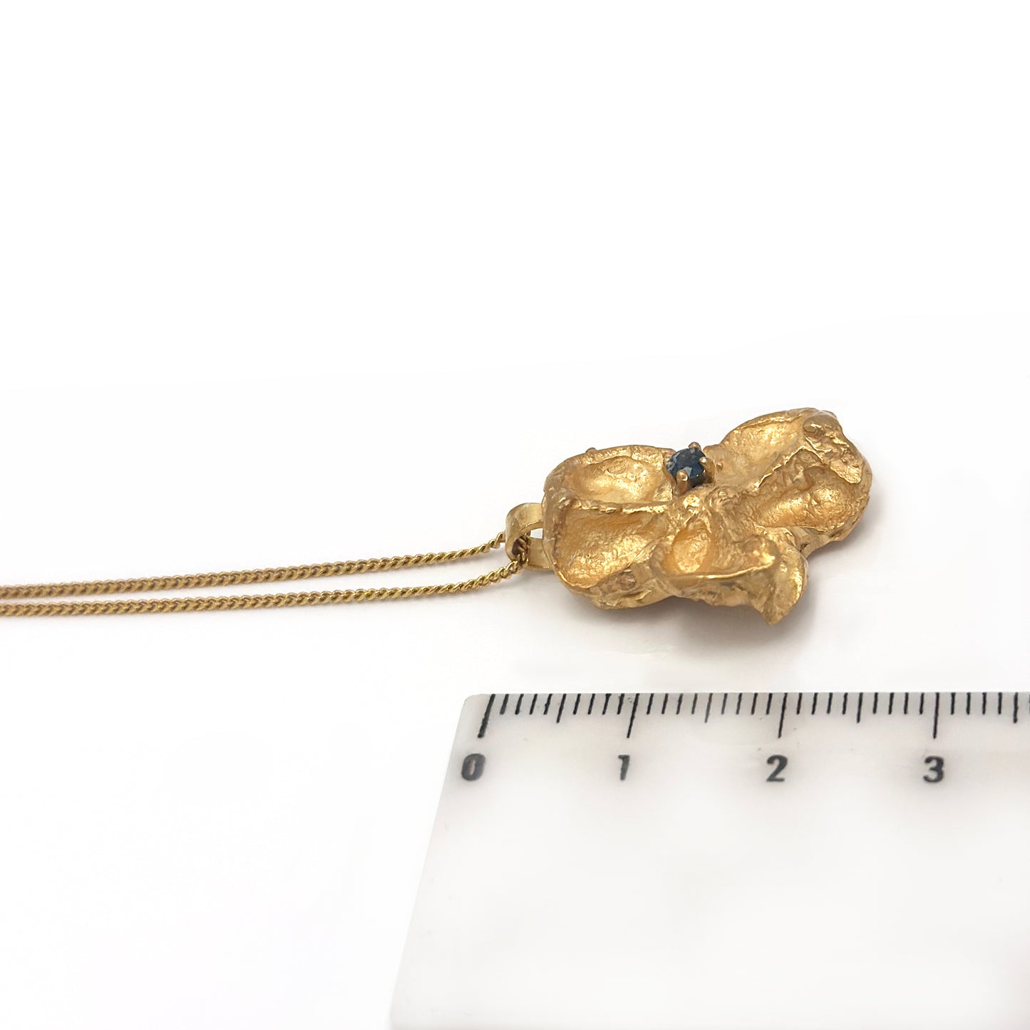 Sculptural gold-plated sterling silver pendant inspired by Australian Flindersia seed pods, set with a natural blue sapphire — handmade necklace by FR Art Jewellery. measure look