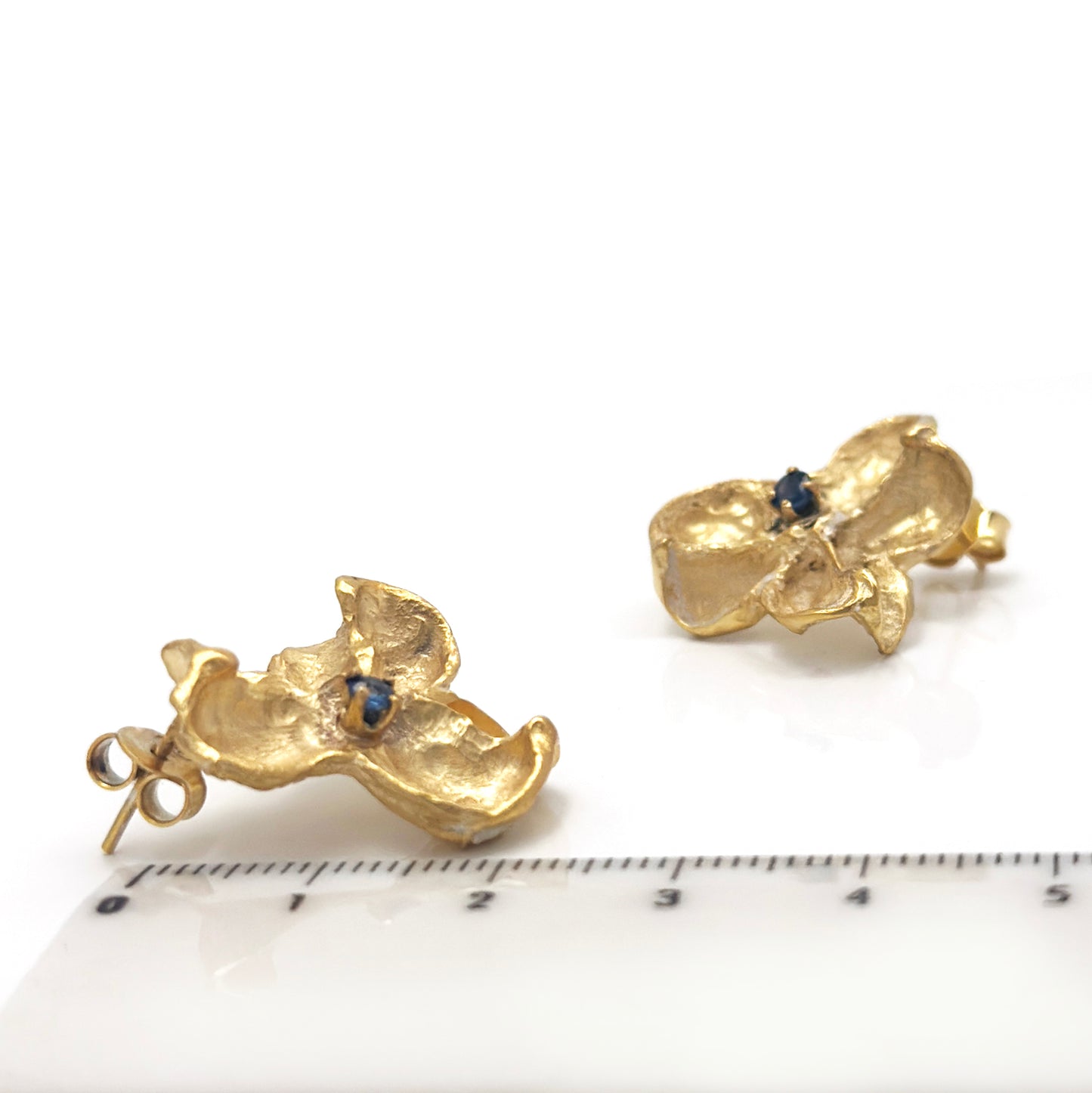 Gold-plated sterling silver sculptural stud earrings inspired by Flindersia seed pods with blue sapphires set in the centre — handmade by FR Art Jewellery. measure look