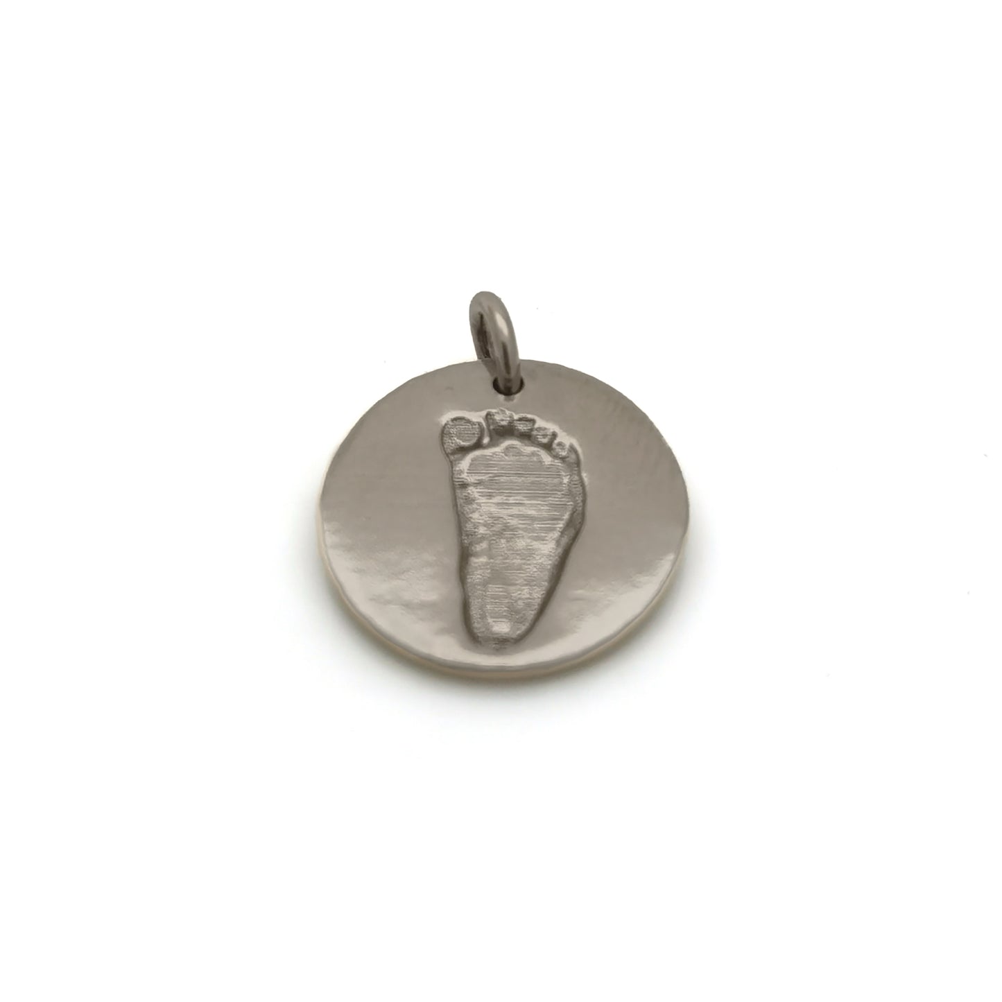 Introducing the Footprint Necklace from FR | Art Jewellery: part of our exquisite Footprint Collection, this silver necklace boasts a simple chain adorned with a circular baby footprint pendant. The pendant features an engraved imprint of a small footprint, offering a personal and delicate touch to this beautiful piece. With its plain white background, this personalized keepsake stands out as a perfect memento.