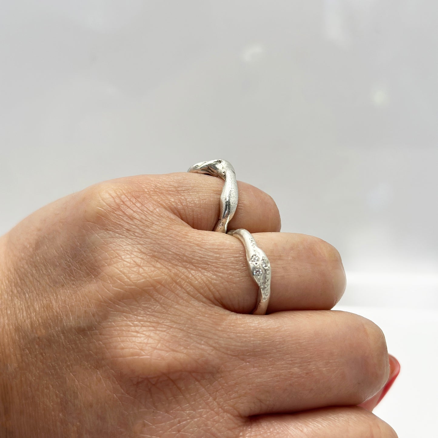 Handmade sterling silver ring with three white diamonds by FR | Art Jewellery, Sydney – organic sculptural band with natural curves and polished finish in hand