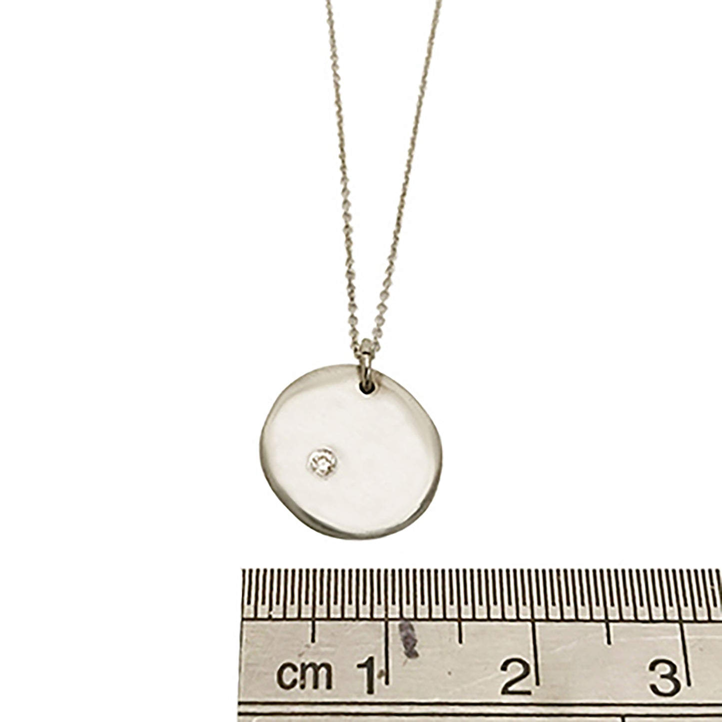 The Full Moon Necklace by FR | Art Jewellery is a delicate gold piece that features a round pendant with a small diamond embedded in the center. The thin chain perfectly complements the simple yet elegant design of the pendant, which boasts a smooth, slightly irregular surface. This necklace exemplifies the craftsmanship of handmade jewellery.