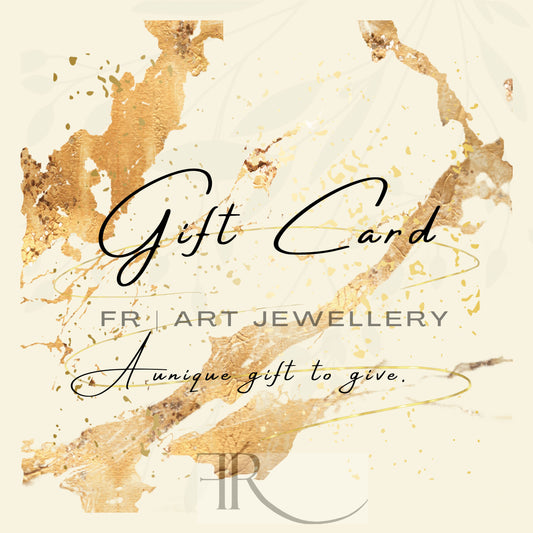 A gift card with an abstract gold and beige background features the text "Gift Card" in elegant script, followed by "FR | Art Jewellery" and "A unique gift to give." The FR logo is positioned at the bottom. This elegant FR | Art Jewellery e-Gift Card makes the perfect present for any occasion.