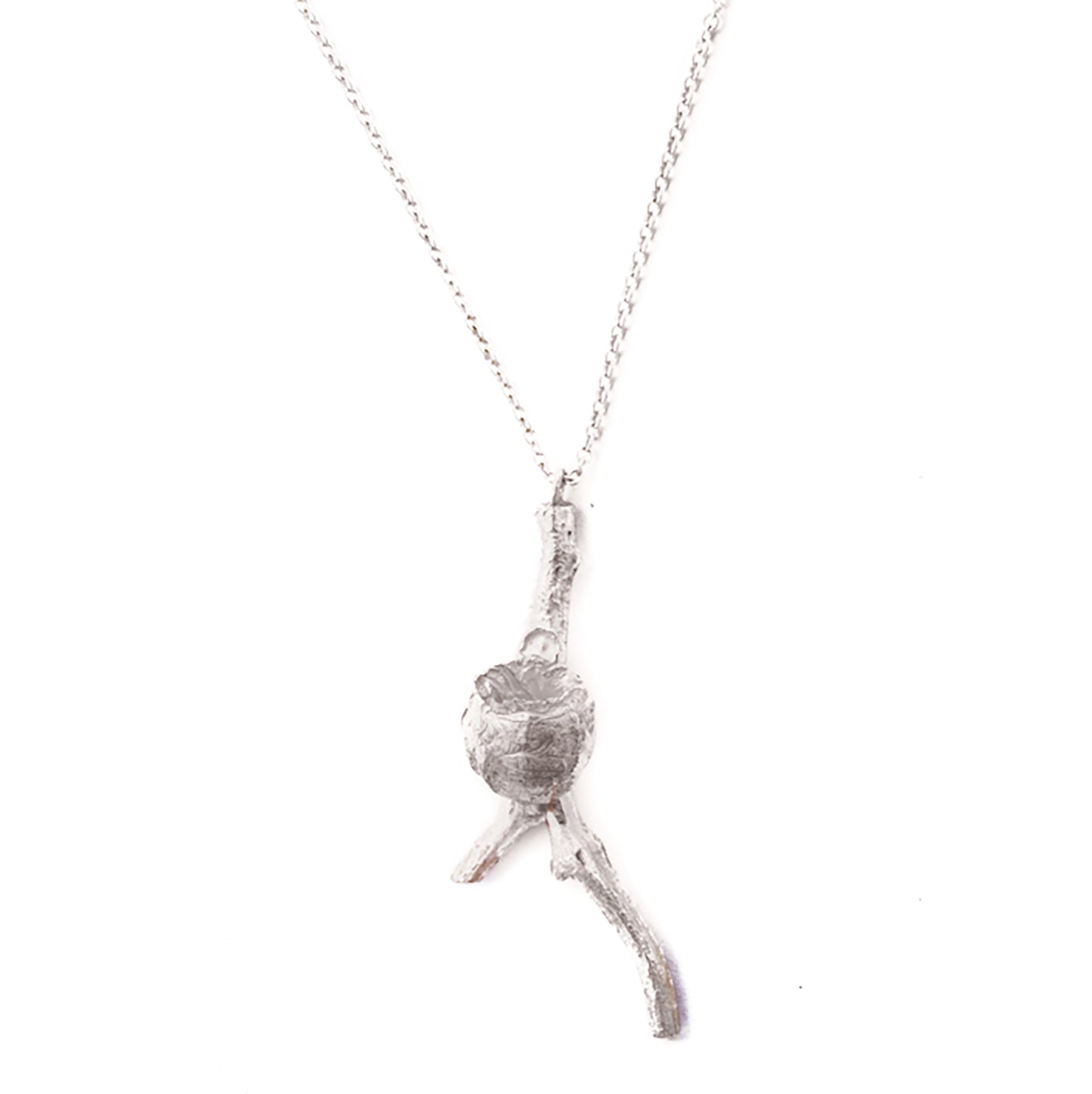 The Gum Stick Seed Necklace from FR | Art Jewellery showcases a pendant shaped like a small, textured tree branch with a knot in the middle. The pendant hangs from a delicate chain, creating a natural and organic aesthetic. Embrace the uniqueness of handmade jewellery with this piece set against a white background.