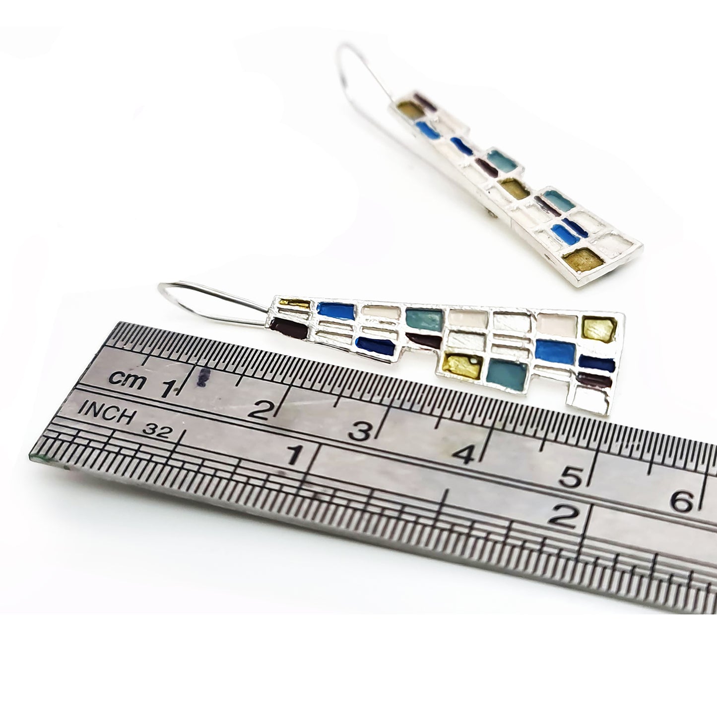 Introducing the Gustav Small Earrings by FR | Art Jewellery: A pair of handmade, dangling earrings showcasing a mosaic design with tiny squares and rectangles in a vibrant array of blue, green, purple, and beige. These silver-set earrings offer a geometric and modern aesthetic, making them perfect for custom-made orders.