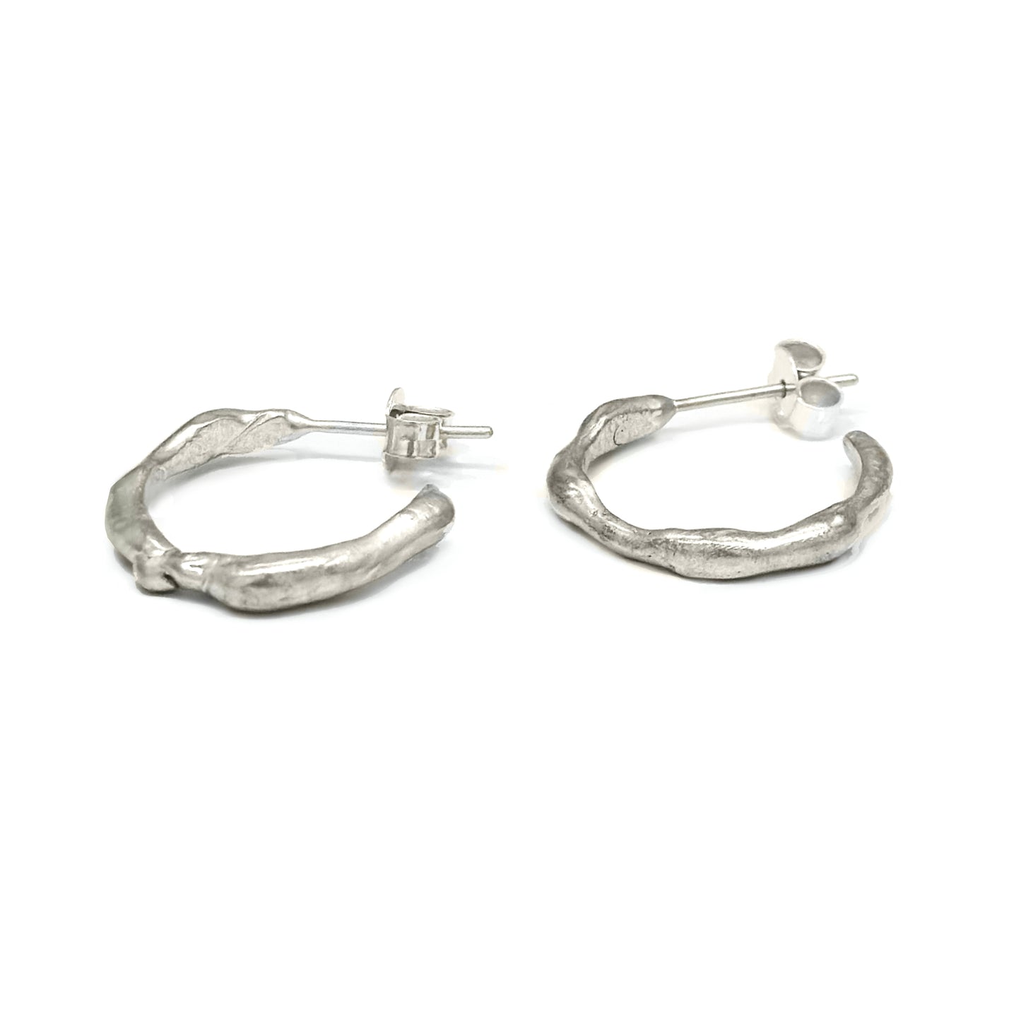 A pair of Hoop 10mm earrings by FR | Art Jewellery, crafted from Sterling Silver with an irregular, textured wavy design, placed on a white background. These handmade pieces feature visible stud fastenings.