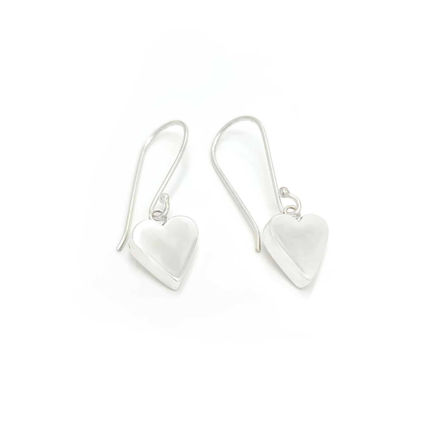 Introducing the "In Love Earrings" by FR | Art Jewellery, these handmade silver heart-shaped dangle earrings feature a smooth, polished surface that subtly reflects light. They hang gracefully from thin hooks and are showcased against a plain white background.